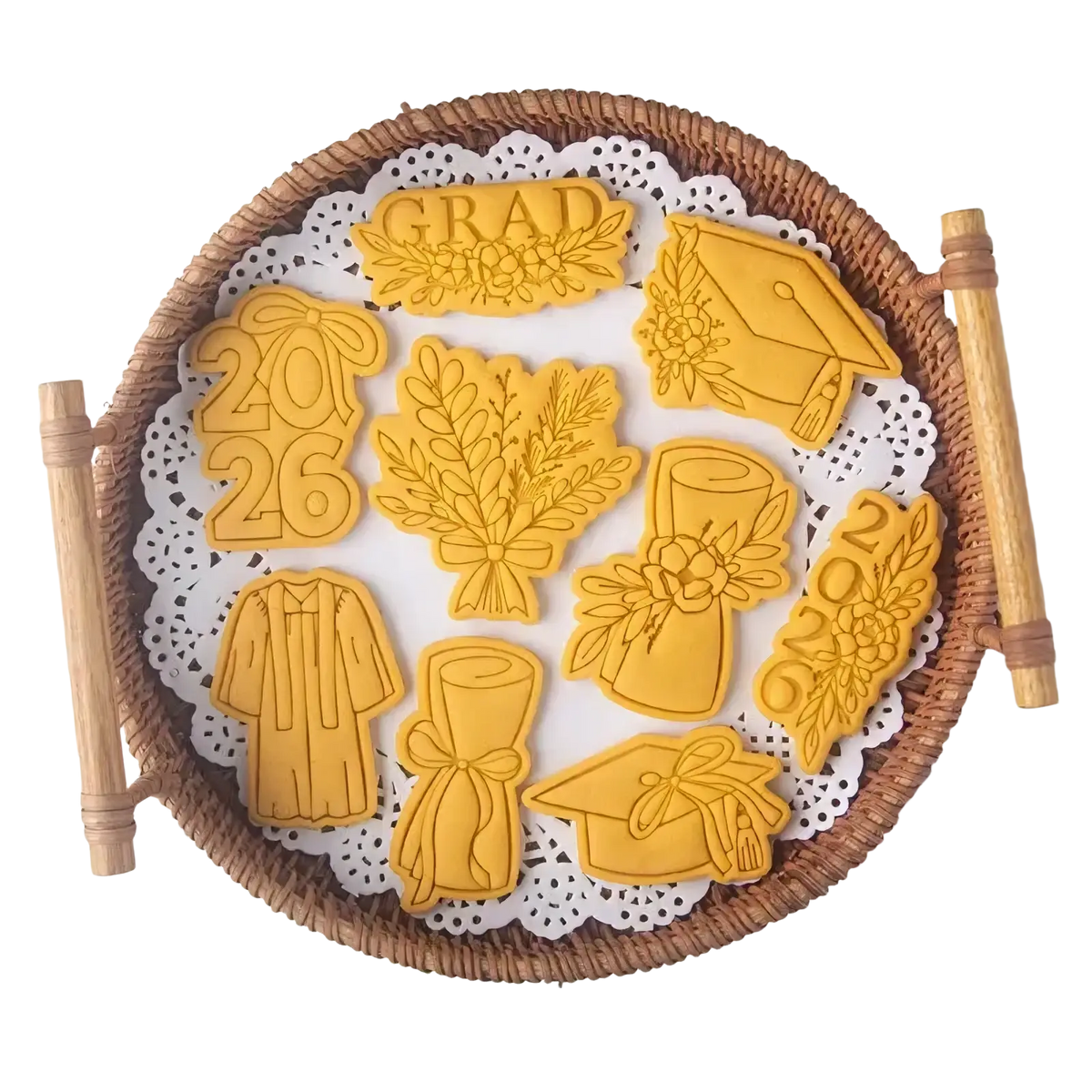 Golden 2026 graduation cookie cutter set features caps gowns diplomas shaped sugar cookies arranged on woven basket