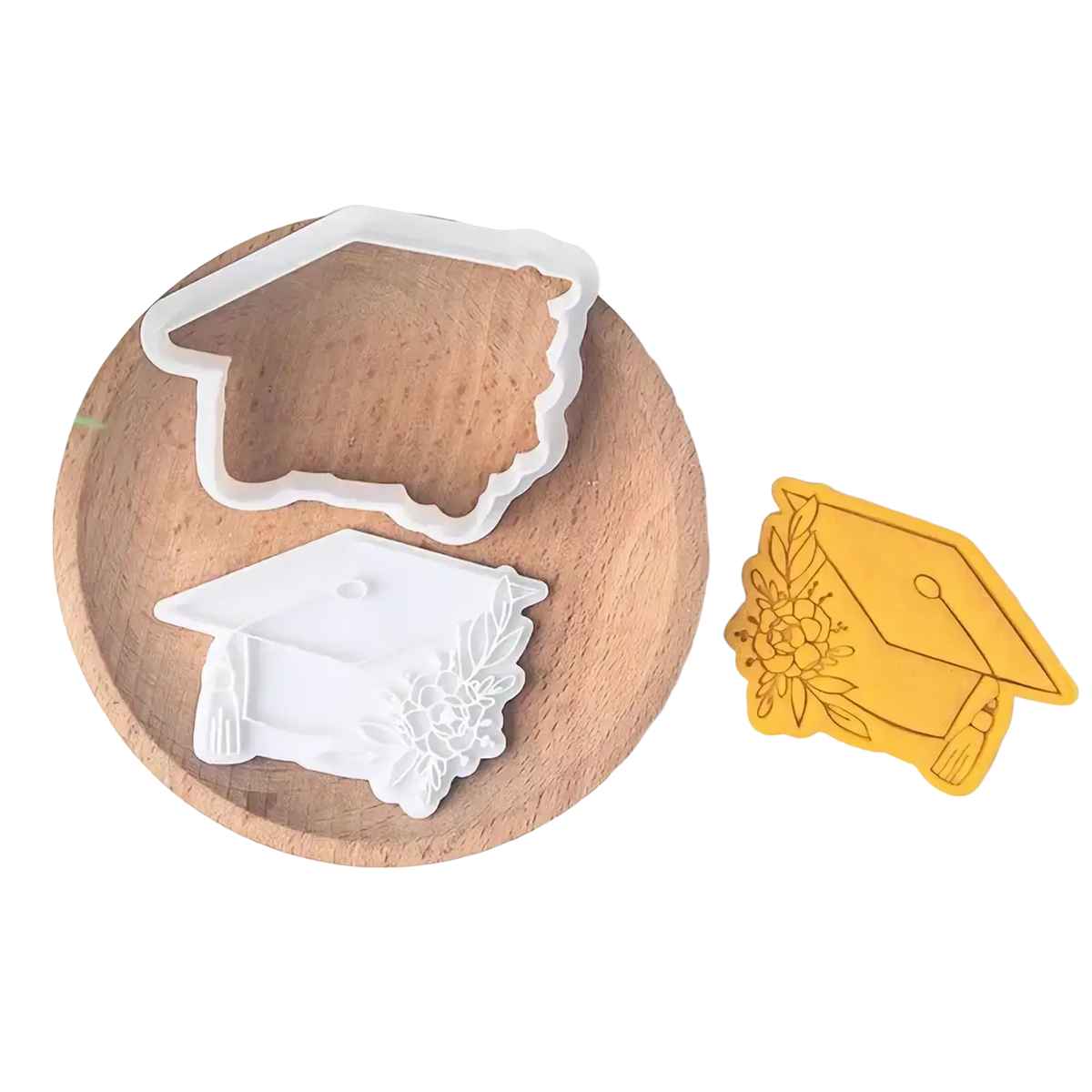 White graduation cap cookie cutter with floral detailing from the 2026 graduation cookie cutter set