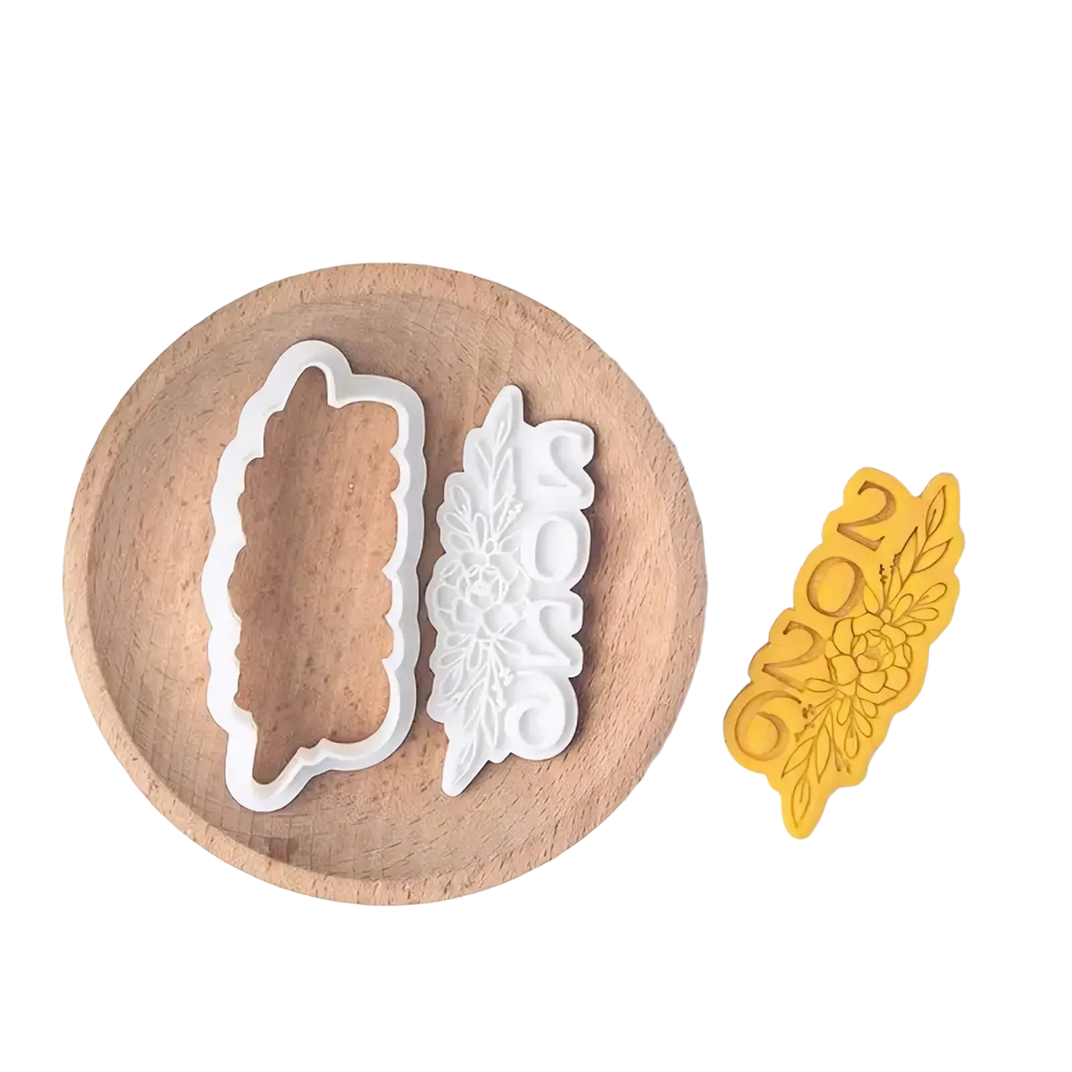 White plastic 2026 graduation cookie cutter set with intricate floral leaf designs shaped like feather and plaque
