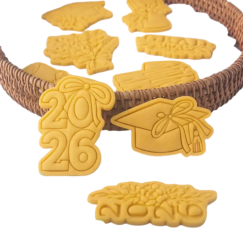 Yellow plastic 2026 graduation cookie cutter set featuring caps tassels and year designs for themed baking