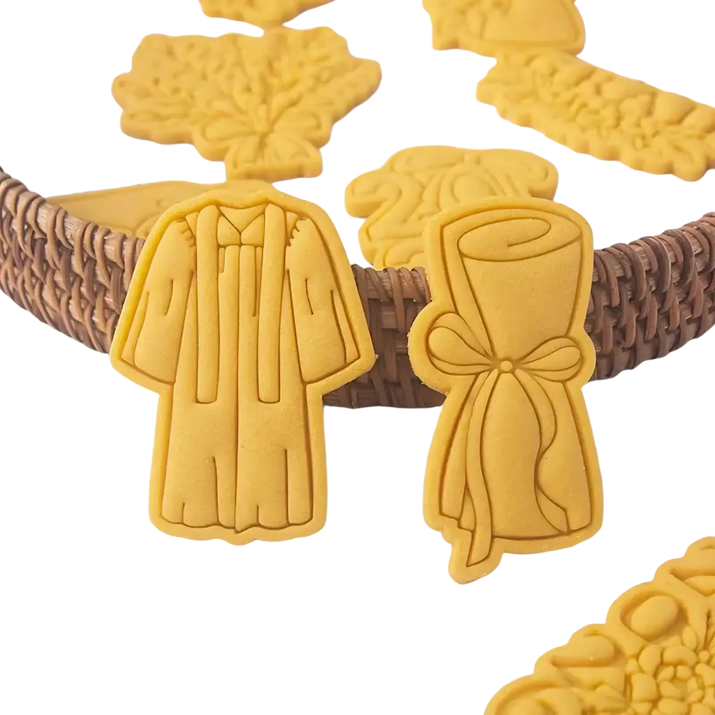 Yellow 2026 graduation cookie cutter set featuring gown and diploma-shaped baked dough cookies for celebration use