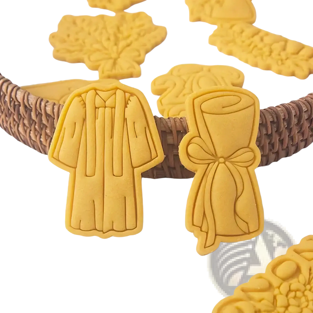 Yellow 2026 graduation cookie cutter set featuring gown and diploma-shaped baked dough cookies for celebration use