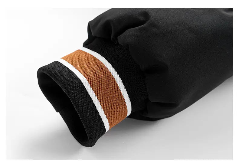 Manga negra de la chaqueta acolchada tipo puffer con capucha para hombre y estampado de letras, con puño acanalado, que presenta dos franjas blancas y una franja beige más ancha.