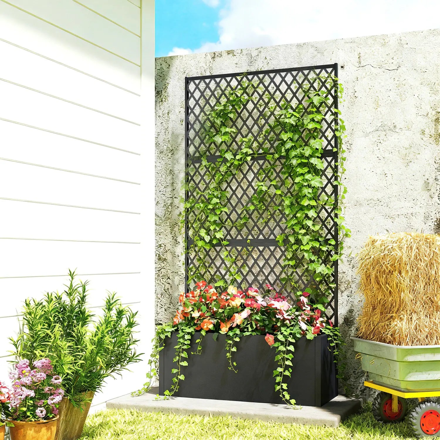 Black metal trellis planter box with a lattice design supporting climbing green vines in a raised garden bed style.