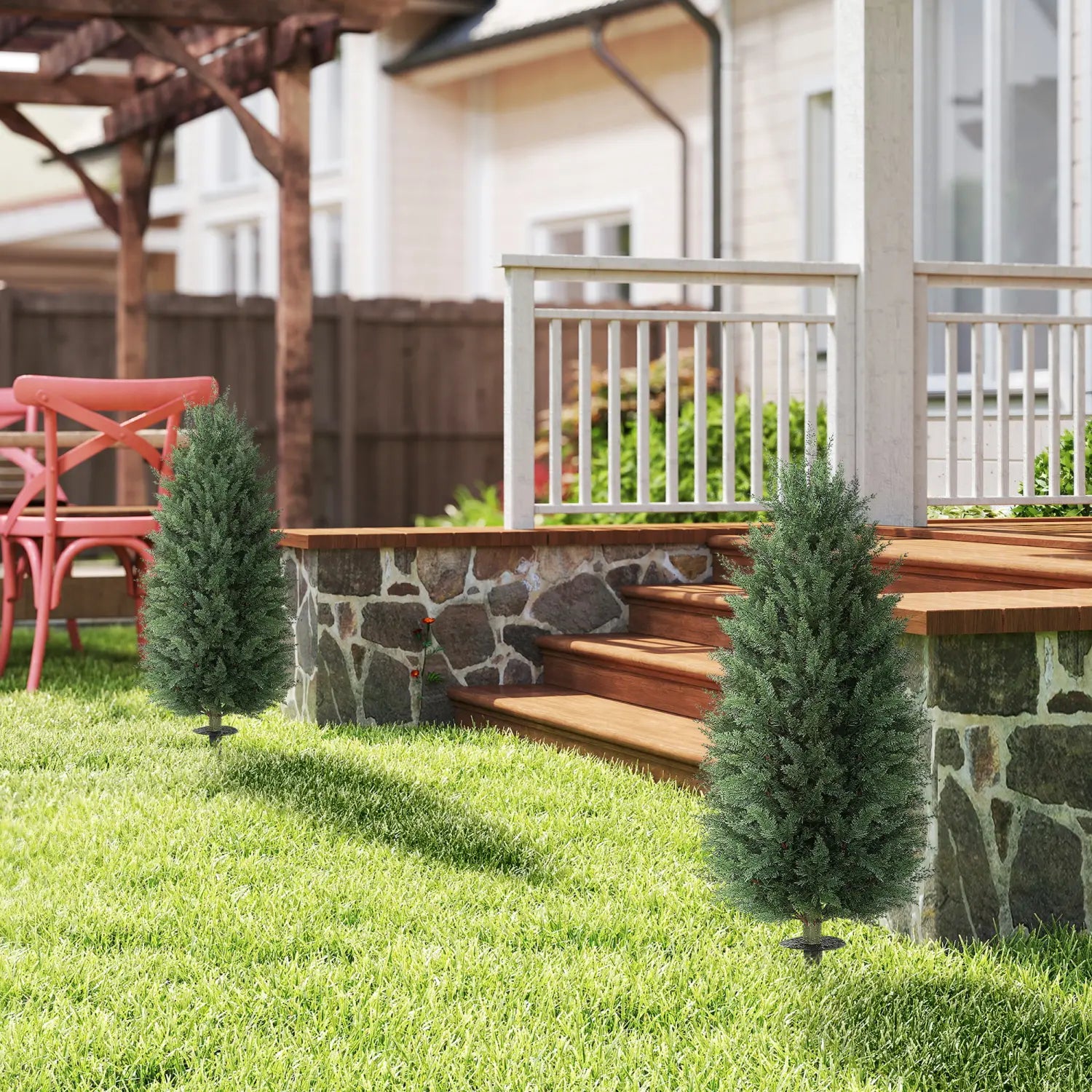 Two artificial cypress topiary trees 43 inch set of 2 with dense dark green foliage and conical shape on black metal stakes standing in the grass.