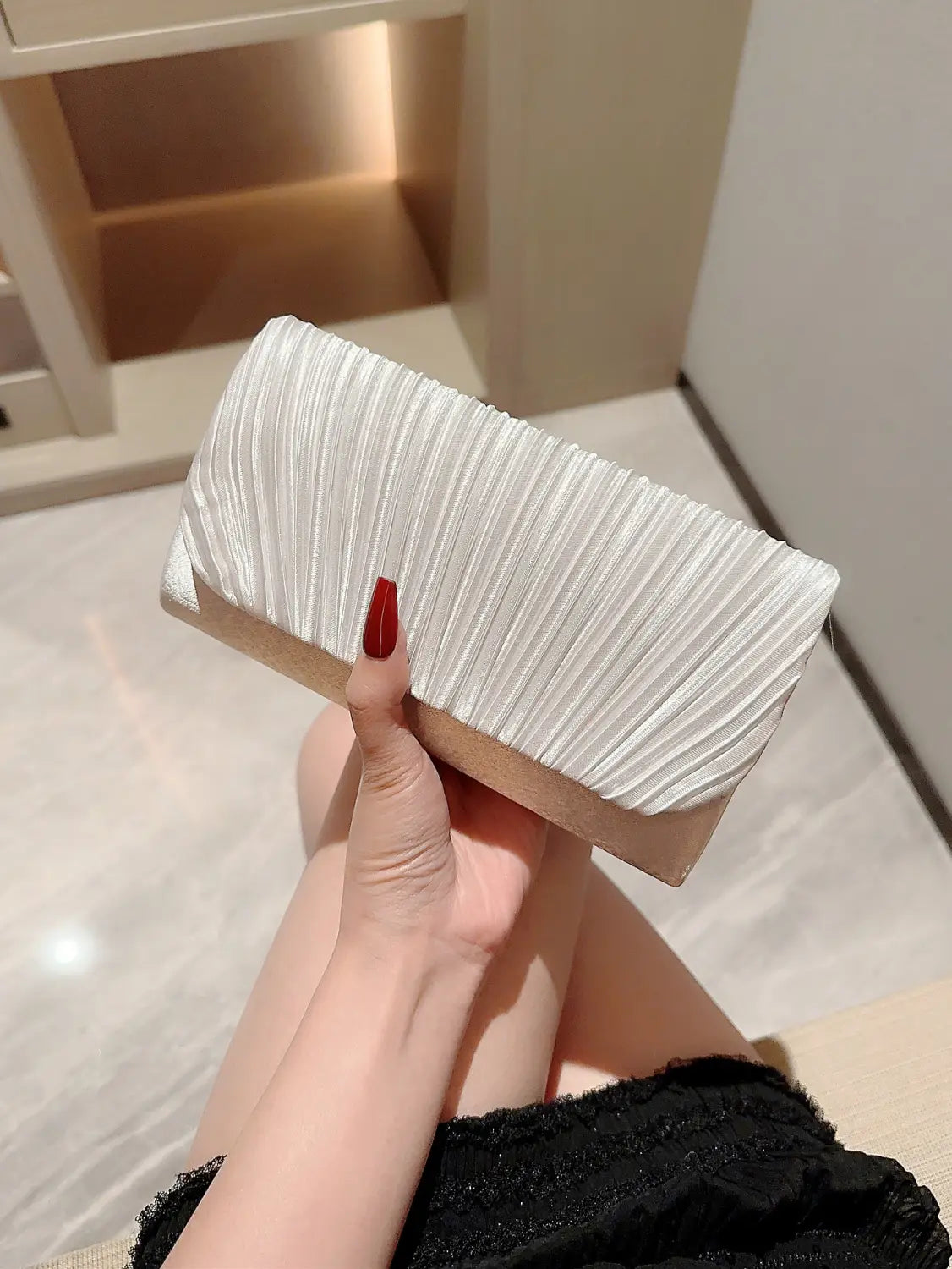 A sleek white pleated satin clutch with a soft finish and a contrasting beige base designed as a minimalist women’s evening bag.