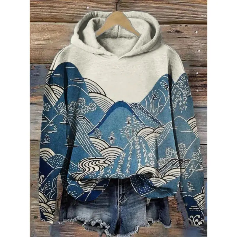 Sudadera con capucha de estampado de olas japonesas gris jaspeado suave, con un diseño vibrante de paisaje montañoso en azul y blanco en la parte delantera y las mangas.
