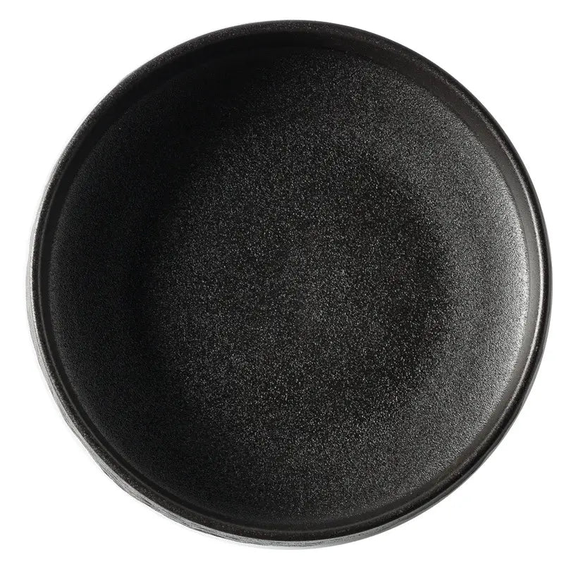 Plato hondo de piedra de cerámica negra con patrón de piedra, acabado mate moteado y borde ligeramente elevado para vajilla japonesa.