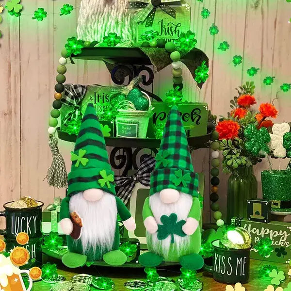 Zwei plüschige grüne Leprechaun-Gartenkobold-Figuren mit schwarzen und weißen Karohüten, Kleeblatt-Dekorationen und langen weißen Bärten für die St.-Patricks-Day-Dekoration in einem 2er-Pack.