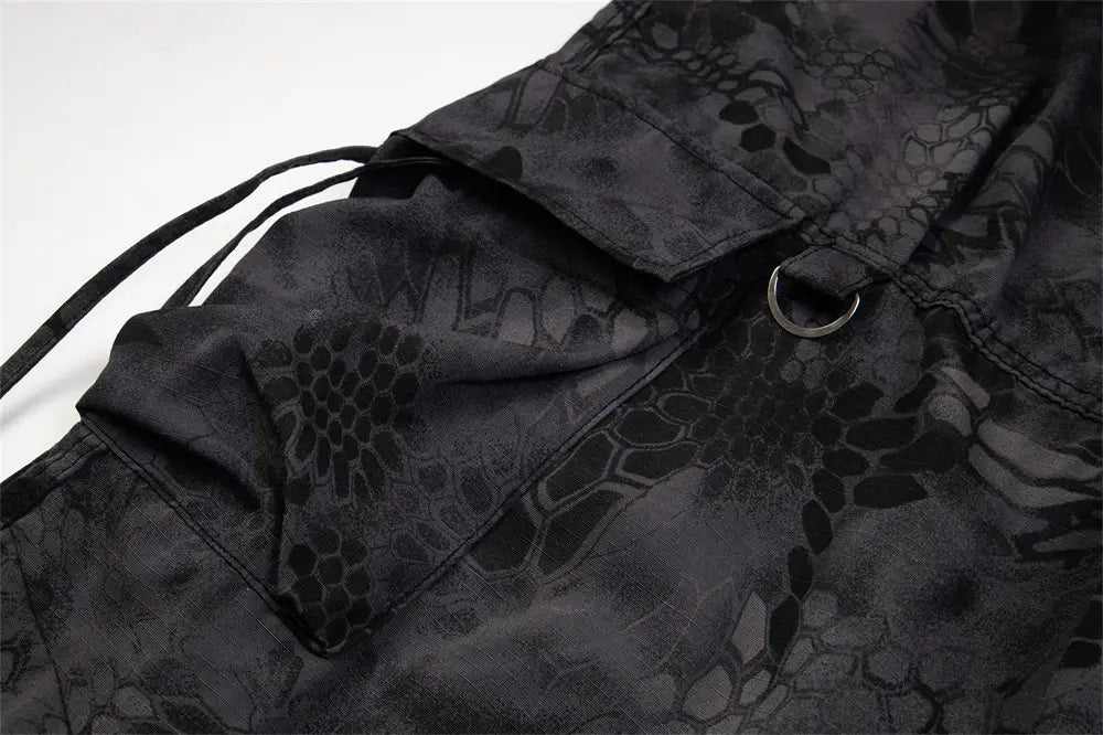 black tactical cargo pants with wide leg design featuring subtle snake-scale camouflage pattern and reinforced stitching for durability in tactical use