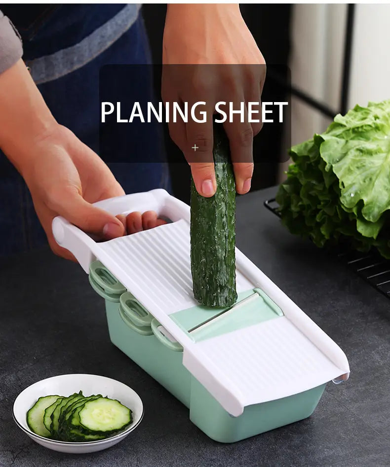 Light green and white plastic vegetable slicer mandoline grater with blades and a planing sheet for slicing cucumbers.
