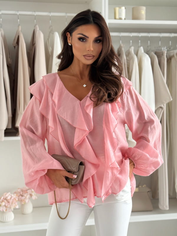 A soft pink ruffled v-neck blouse featuring layered ruffles and voluminous puff sleeves made from lightweight fabric.
