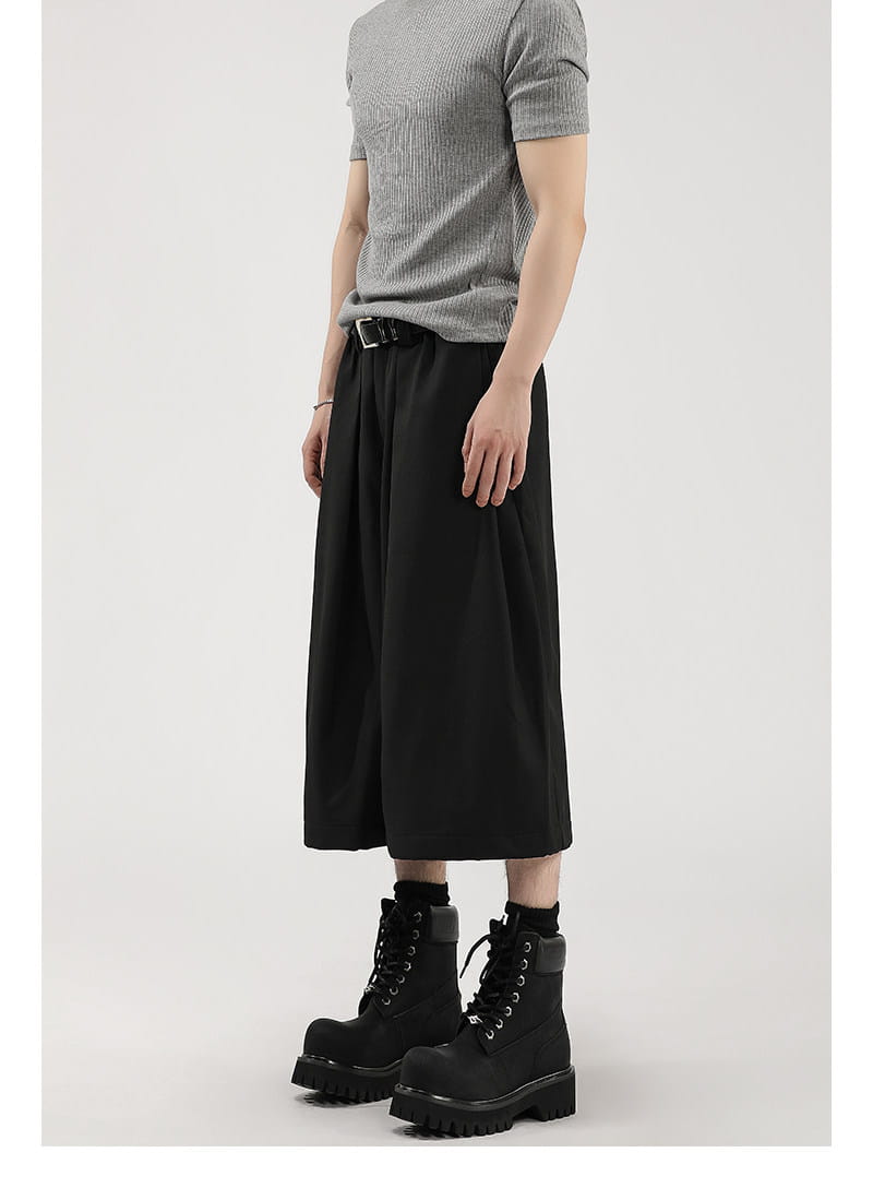 Short de costume pour hommes à jambes larges plissées noir, avec une silhouette fluide décontractée et des plissés discrets dans un tissu léger.