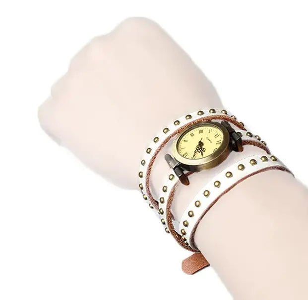 White leather wrap bracelet watch with gold-tone studs and vintage-style face in a vintage leather studded wrap watch bracelet design.