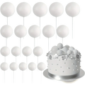 White spherical foam ball cake toppers with thin sticks arranged in rows for birthday and wedding party decoration