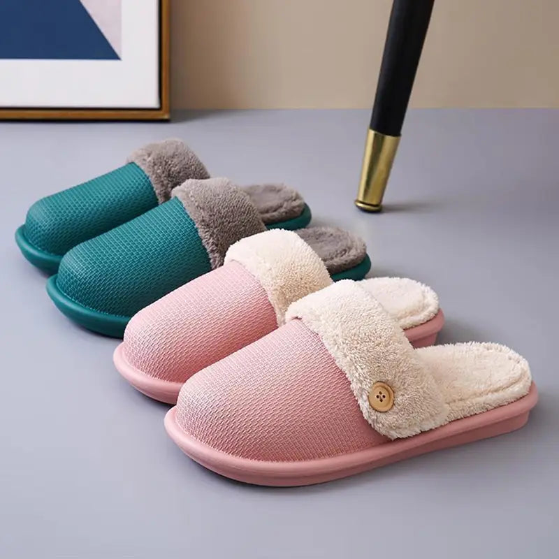 Winter slippers washable plush house shoes for women featuring pink and cream fuzzy slip-on design with textured fabric upper soft plush lining and decorative wooden button on the strap.