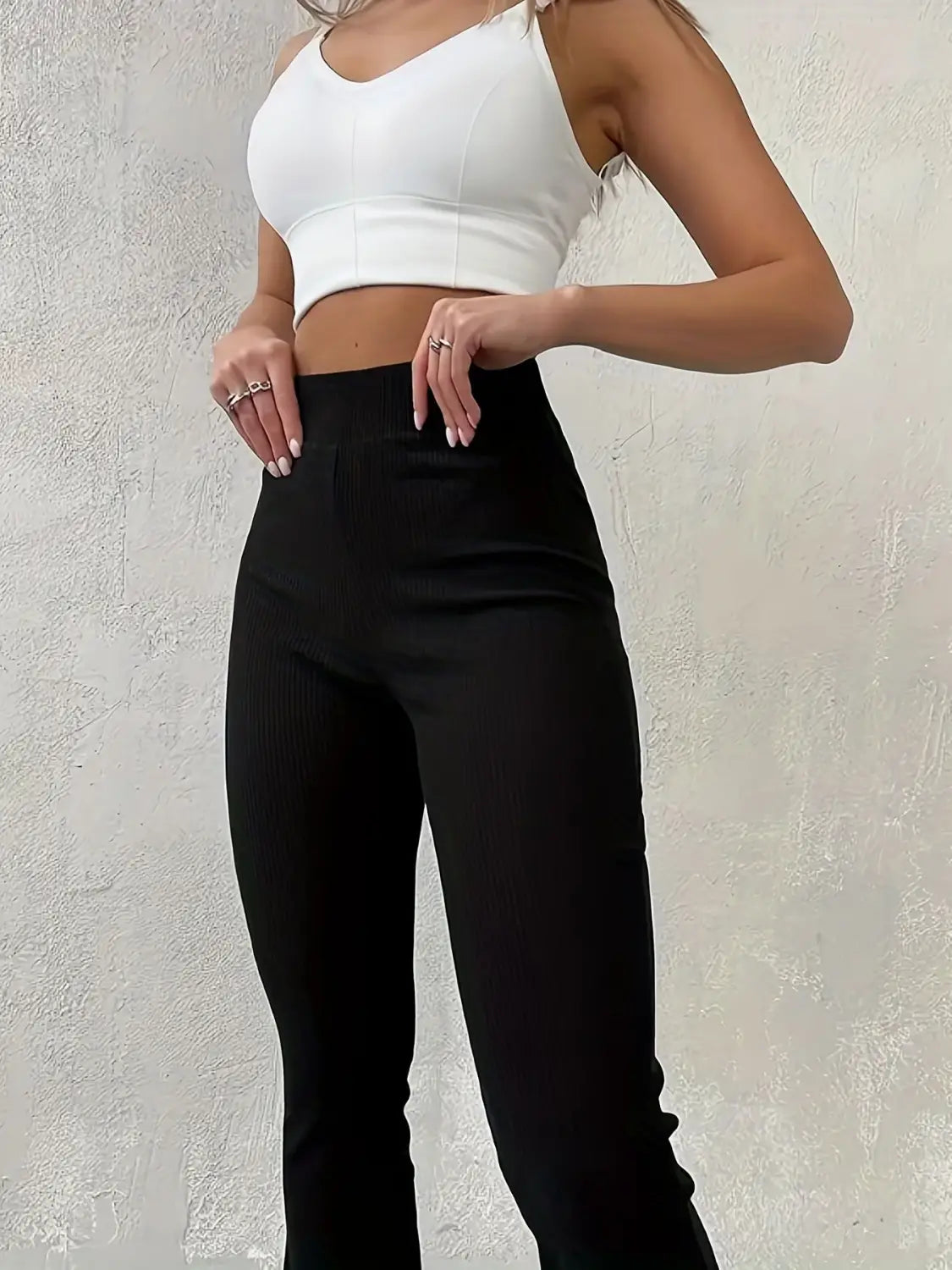 Schwarze hoch taillierte Ripp-Flared-Leggings mit einer eleganten, körperbetonten Gestaltung und dezenter vertikaler Rippung.
