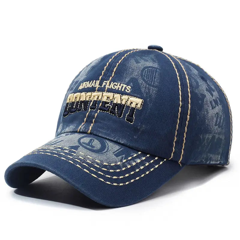 Denim blue distressed washed cotton baseball cap with faded distressing, gold and black embroidered airmail flights content text, and contrasting tan stitching along the brim and panels.