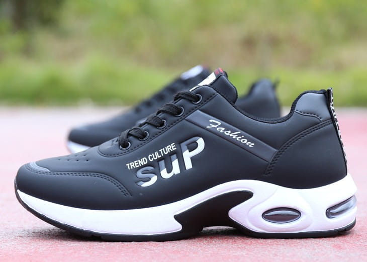 Men’s casual sportswear leather running shoes in black with white soles and air cushioning featuring trend culture sup branding in silver lettering on the side.