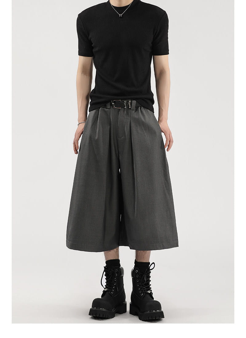 Short de costume pour hommes à jambes larges plissées noir, finition mate et passants de ceinture.