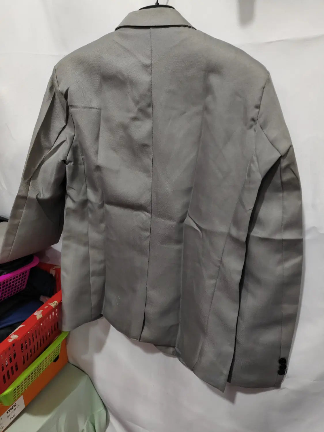 Herren-Slim-Fit-Fuchsia-Freizeitblazer aus grauem Stoff mit dezentem Glanz und schwarzem Besatz entlang des Kragens und der Ärmelbündchen.