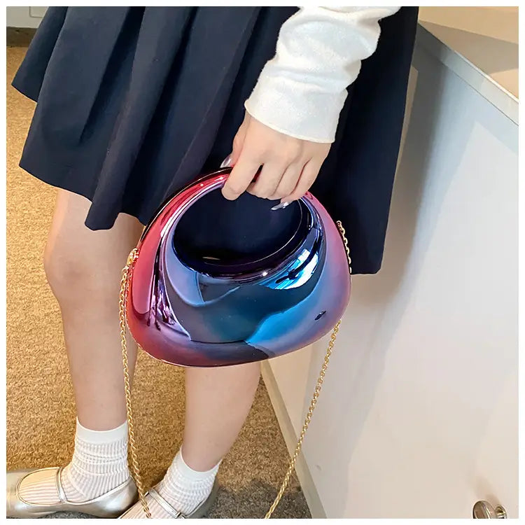 Acrylic gold chain handbag featuring a glossy iridescent finish with a smooth rounded shape and a metallic clutch design.