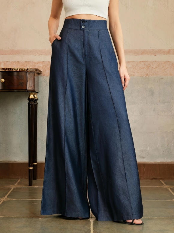 High waisted wide leg trousers in deep indigo denim fabric featuring pleated front panels and button closure.