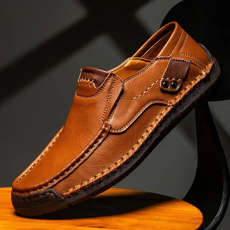 Mocassin en cuir marron pour homme, style décontracté, pour sorties en plein air, avec des coutures visibles et une semelle sombre contrastante.