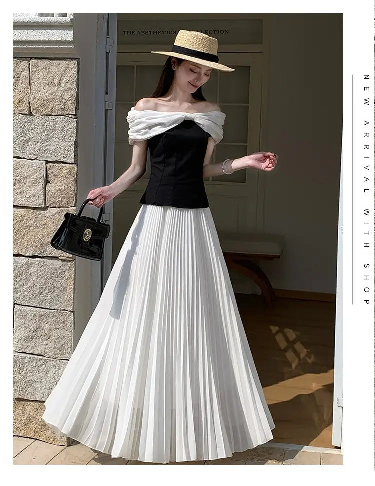 Schwarze Lederhandtasche mit goldfarbenem Verschluss und strukturiertem Design, passend zum plissierten Chiffon-Maxirock für Damen.