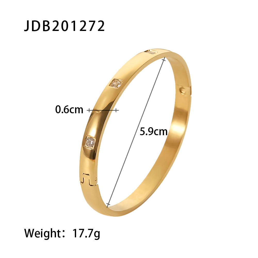 Gold plated stainless steel bangle bracelet in gold tone featuring three square cut clear zirconia gemstones set along its surface.