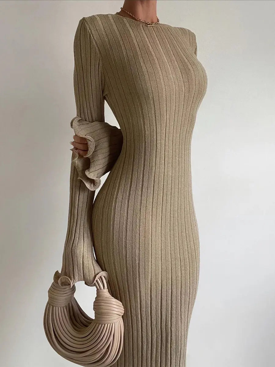 Back side view of a beige ribbed knit long-sleeve bodycon maxi dress with ruffled cuffs featuring a backless design.