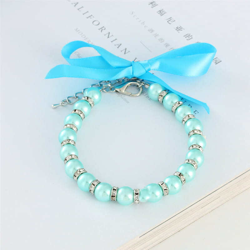 collier de perles pour animal à ruban pastel délicat couleur turquoise, orné d’accents en cristal à finition argentée et d’un nœud en satin bleu assorti.
