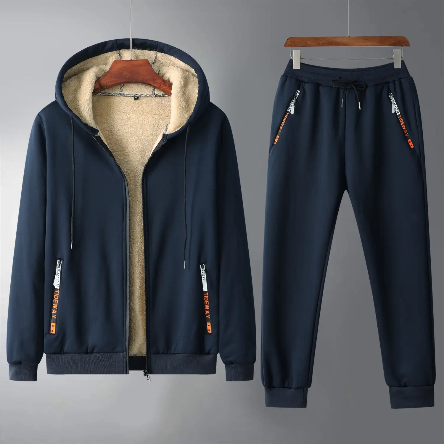 Men fleece lined tracksuit set in navy blue featuring a fleece lined hooded sweatshirt and matching joggers with orange branding on the sides.