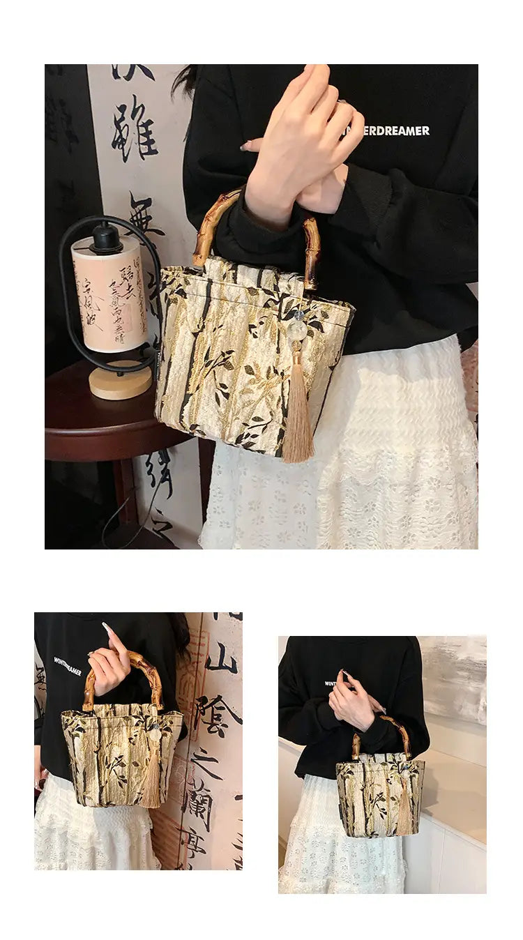 A beige and brown bamboo-patterned bucket bag with woven handles made of canvas featuring a tassel and forest pattern.