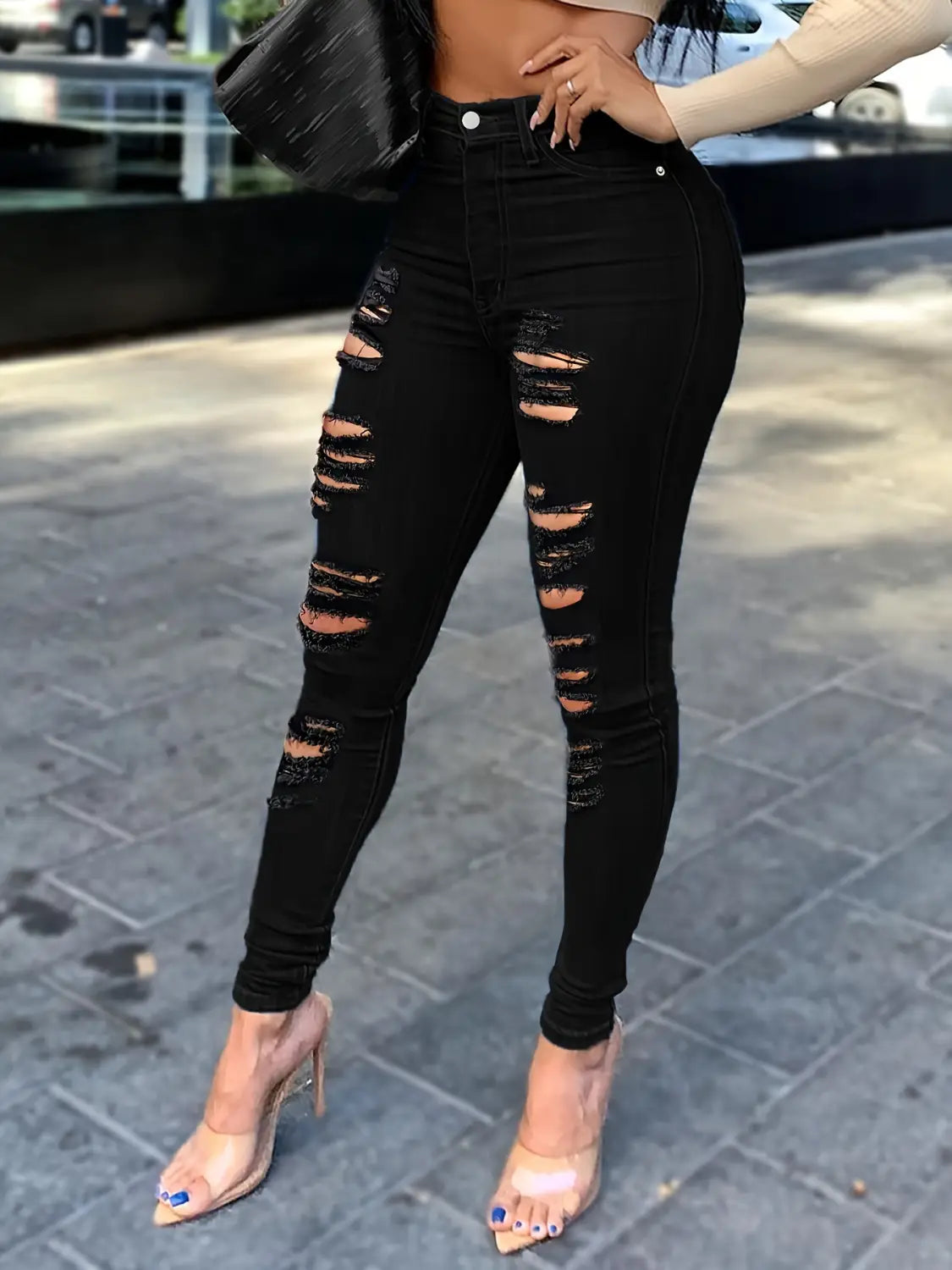 Jeans skinny taille haute échancrés noirs présentant des empiècements délavés et des fermetures à boutons argentés en denim noir.