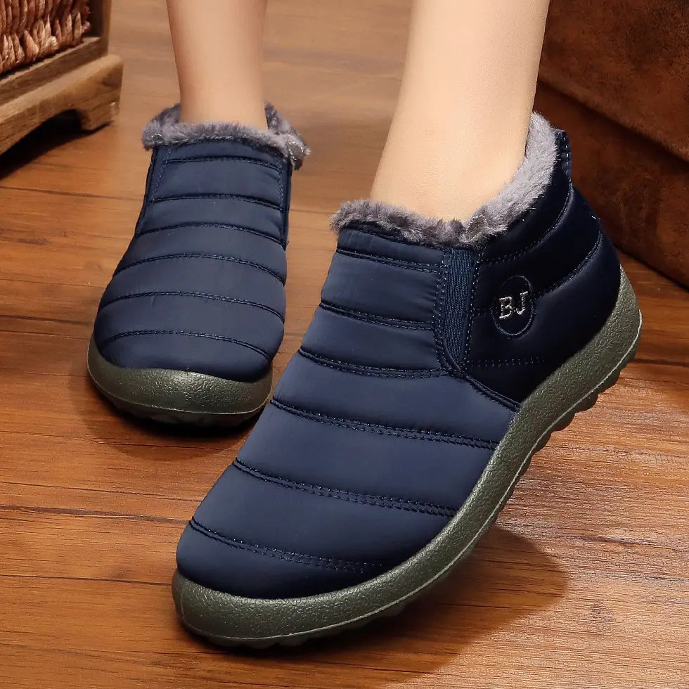 Men snow boots in navy blue quilted fabric with gray faux fur lining and olive green rubber soles designed as lightweight waterproof winter shoes.