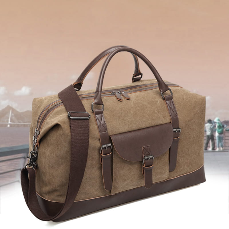 Tan canvas duffel bag with brown leather handles straps and accents large travel handbag with leather trim.