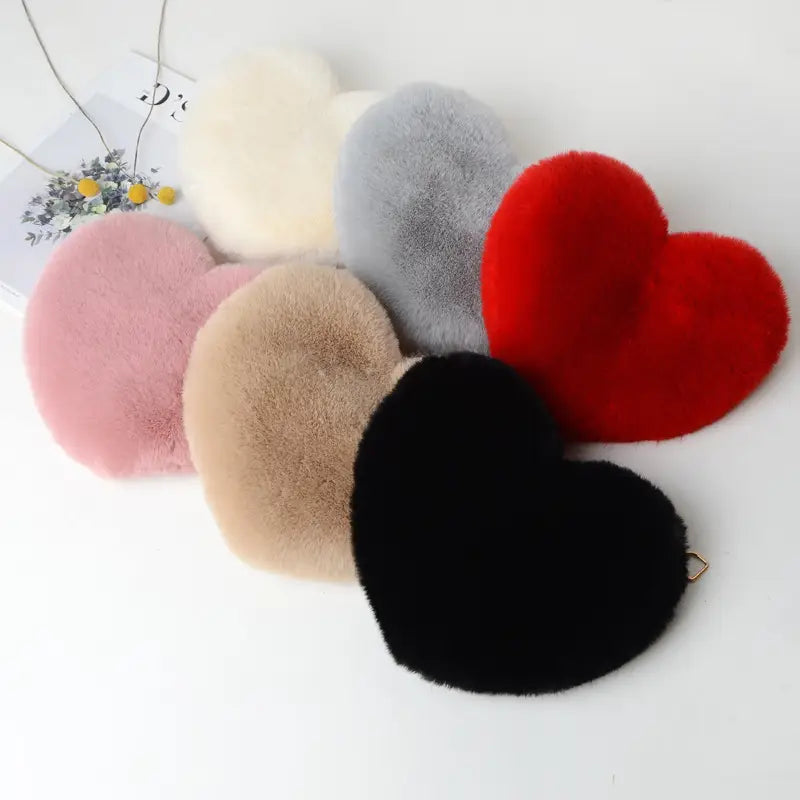 Soft plush faux fur heart shaped crossbody bags in assorted colors including red black pink beige gray and cream with gold chains.