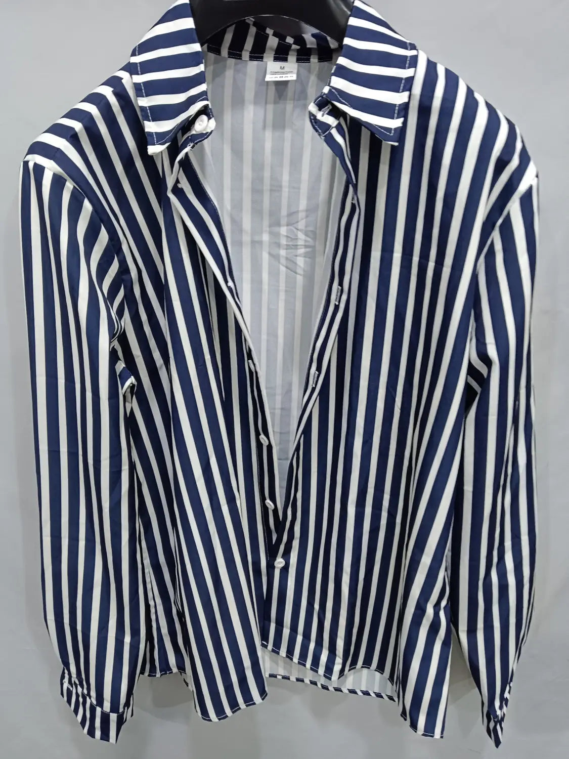 Chemise décontractée à manches longues rayée verticalement bleu marine et blanc pour hommes, avec col classique et patte boutonnée.