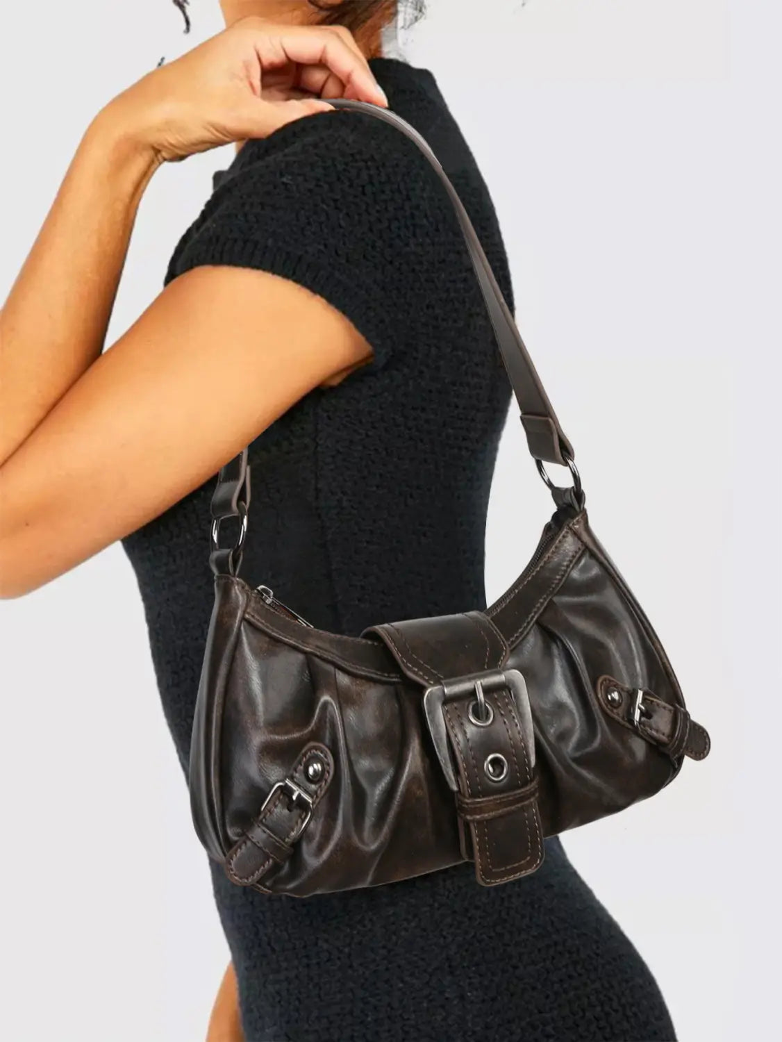 Dark brown vintage leather shoulder bag with prominent buckle closure and adjustable crossbody strap.