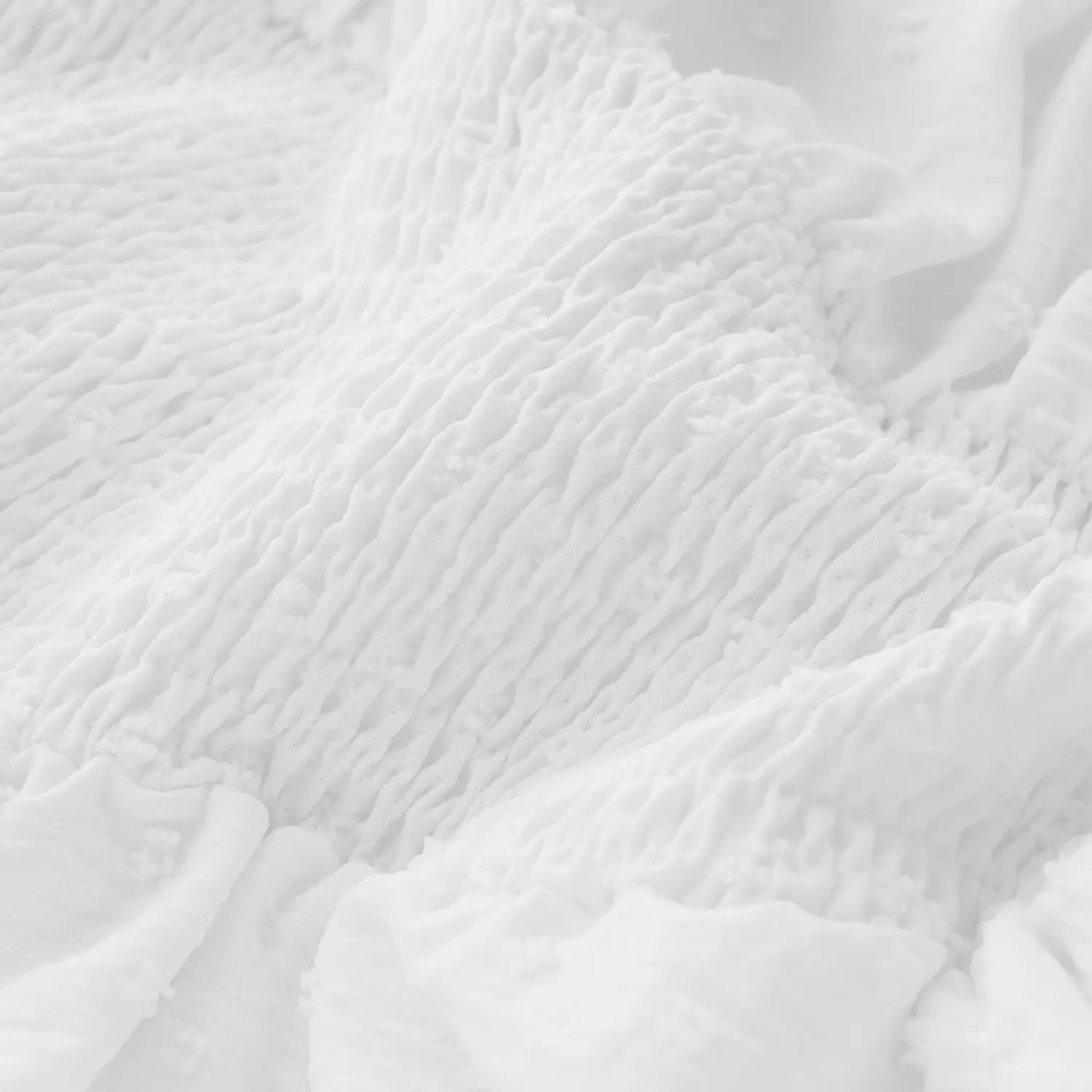 off shoulder long sleeve ruffled tiered mini dress made of white textured fabric with a soft crinkled surface.