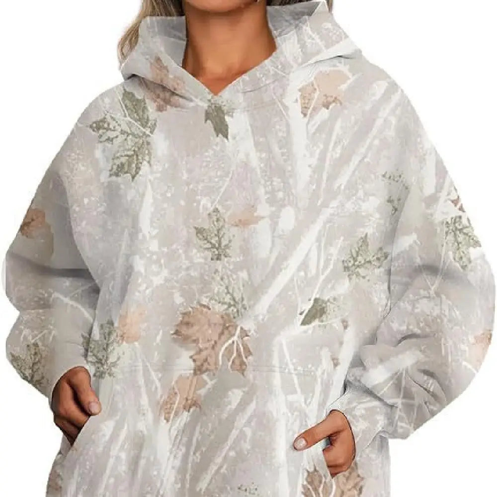 A sheer light gray oversized leafy camouflage hoodie with subtle muted green and beige leaf patterns and lantern sleeves.