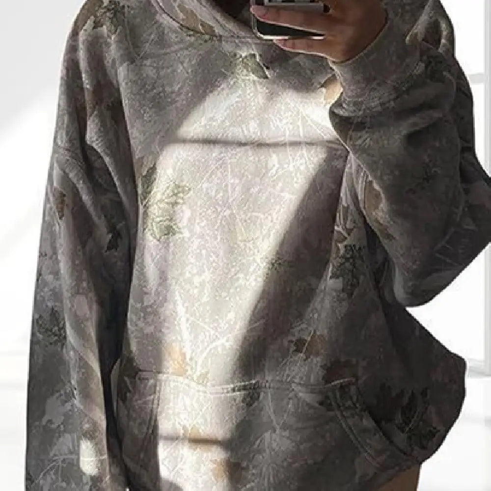 A soft oversized gray hoodie with a subtle leafy pattern and front pockets featuring lantern sleeves designed for casual comfort.