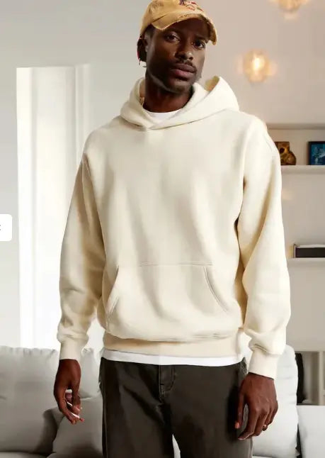 Cream-colored oversized leafy camouflage lantern sleeve hoodie made of soft textured fabric with a relaxed fit and front pocket.