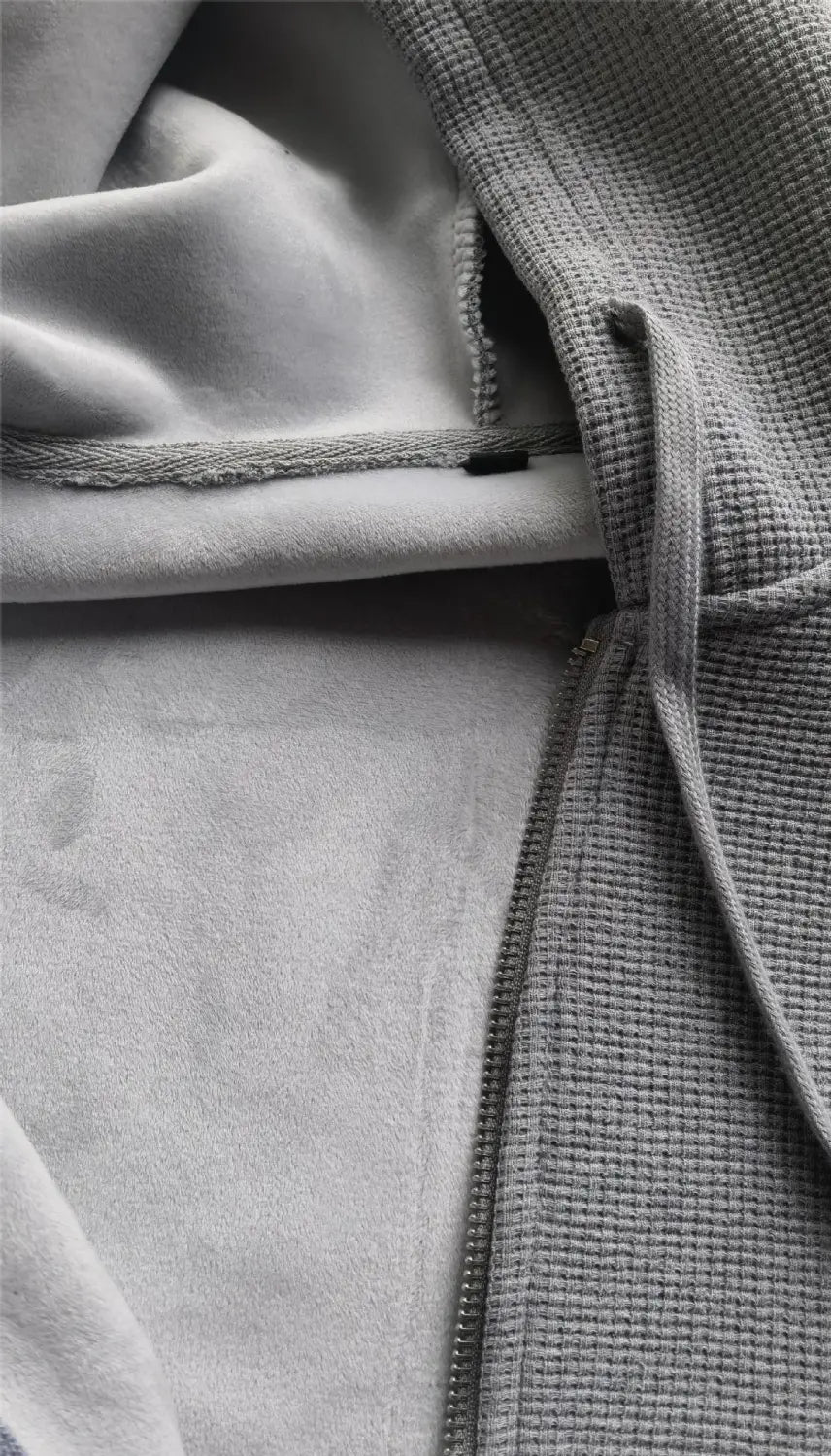 Gray waffle-knit hoodie with soft fleece lining and drawstring hood featured in a waffle hooded sportswear set.