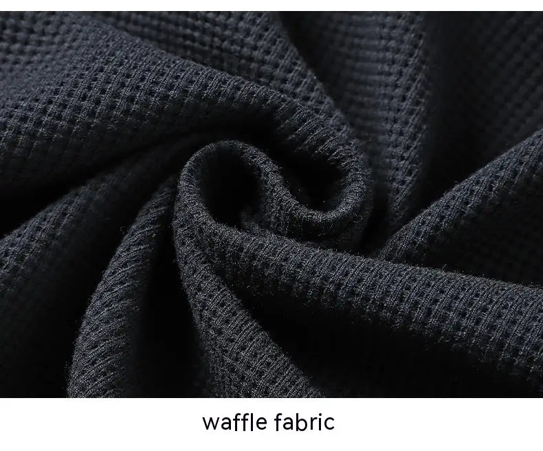 black waffle-knit fabric with a textured grid-like pattern from the waffle hooded sportswear set showcasing its breathable and comfortable material.