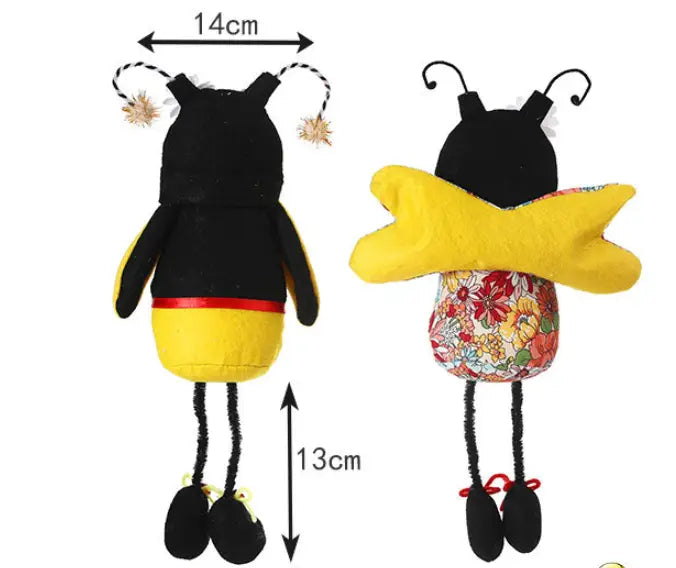 Peluche d’gnome abeille à longues jambes sans visage pour décoration, présentant un motif en forme d’abeille noir et jaune avec un ventre à motif floral, des antennes duveteuses et des jambes en cure-pipe.