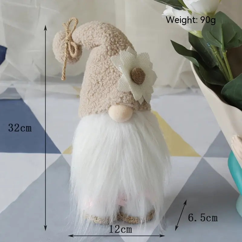 une peluche d’gnome abeille à longues jambes sans visage, avec une fourrure beige, une barbe blanche et duveteuse, et une fleur décorative sur son chapeau, idéale pour la décoration intérieure.