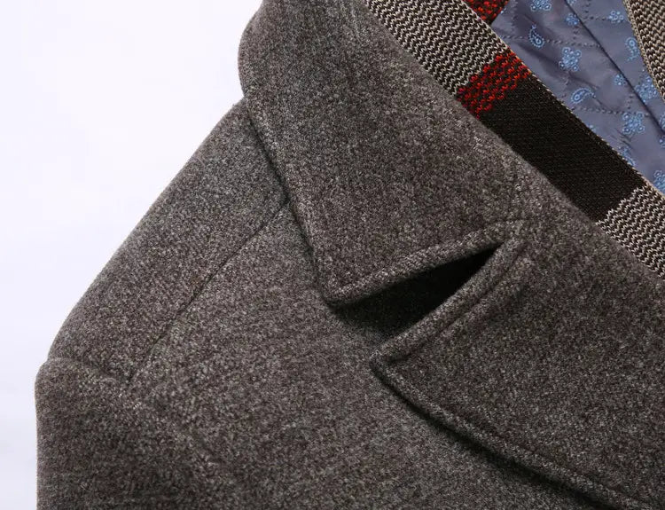 Men wool overcoat in textured gray wool with a classic collar and neatly stitched seams featuring a plaid lined lapel for winter use