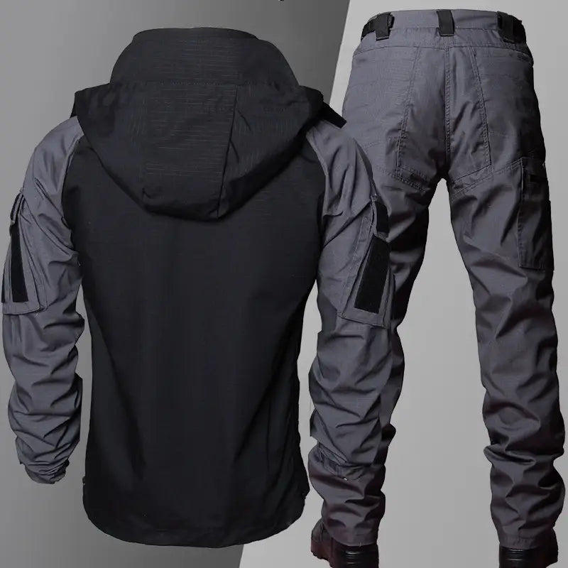dark gray tactical soft shell jacket with black hood and sleeve accents paired with matching cargo pants designed for outdoor and tactical use